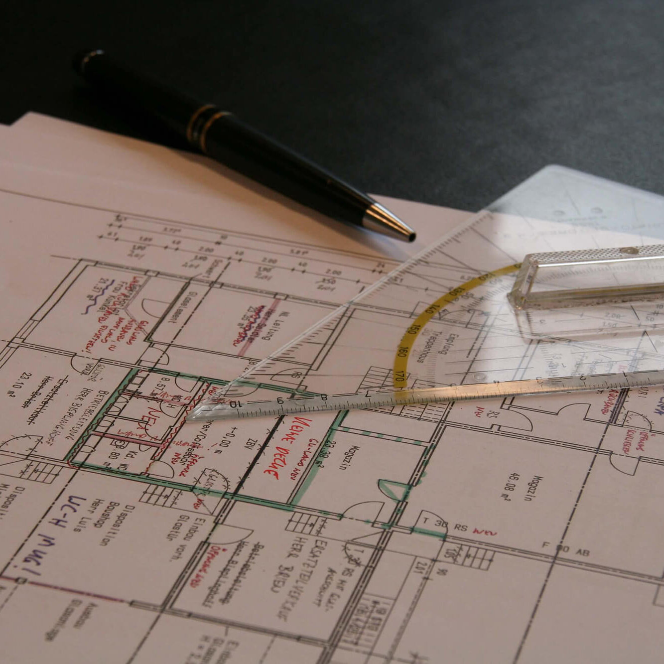 Nahaufnahme eines Gebäudeplans mit Geodreicke und Stift