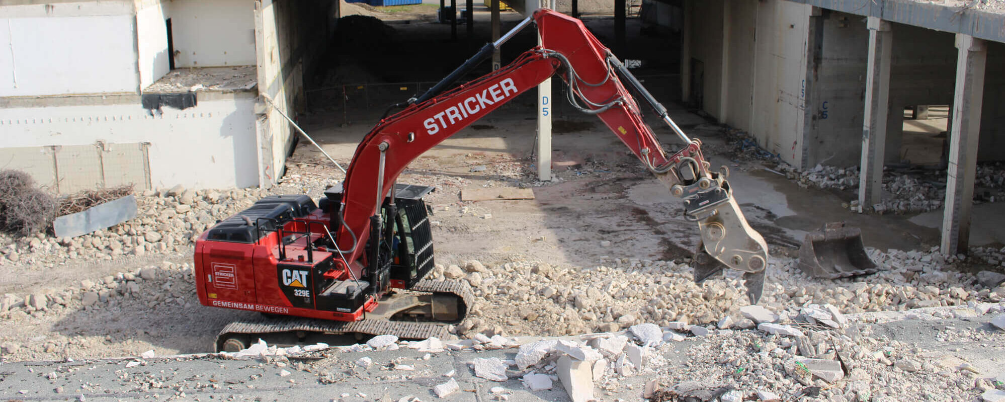 Roter Stricker Bagger bei Abrissarbeiten